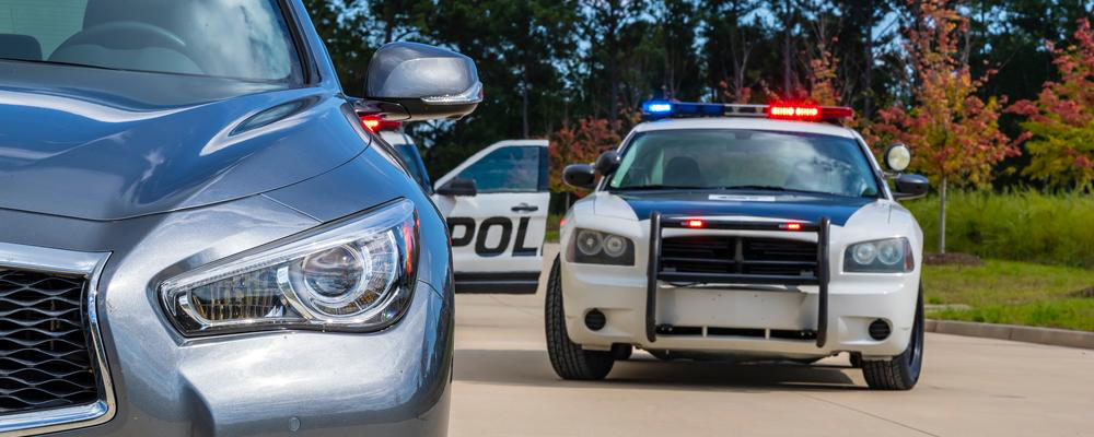 Traffic stop with police cruiser behind a car